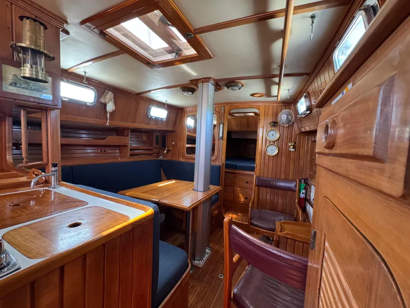 Slide: The Image of Interior of 1988 Cabo Rico 38XL sailboat with wooden furnishings and cozy seating area. - 30