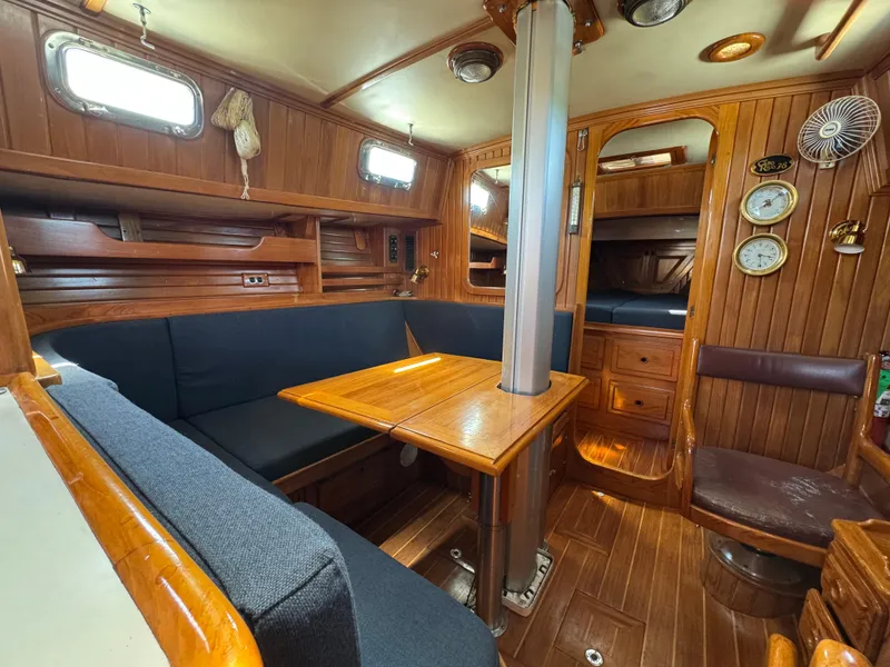 Slide: The Image of Interior of 1988 Cabo Rico 38XL sailboat with wooden furnishings and cozy seating area. - 31
