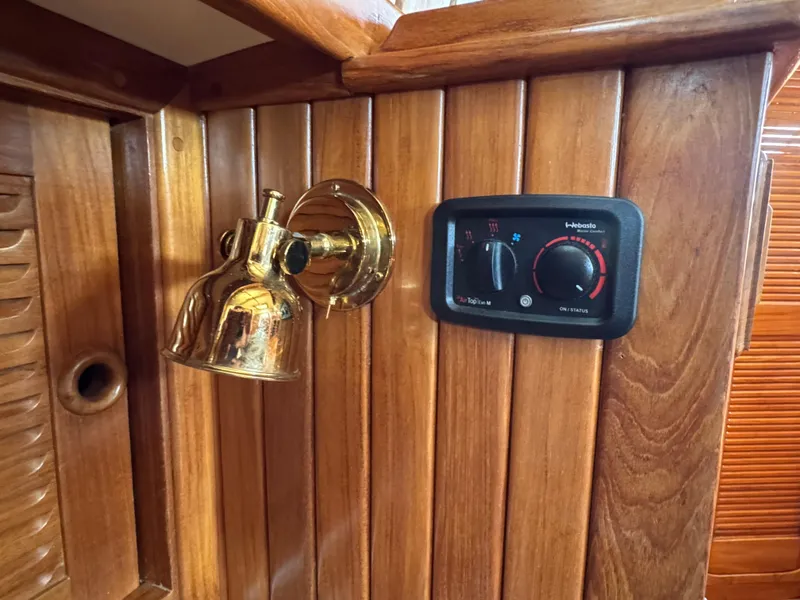 Slide: The Image of Brass light fixture and control panel on 1988 Cabo Rico 38XL yacht's wooden interior. - 36