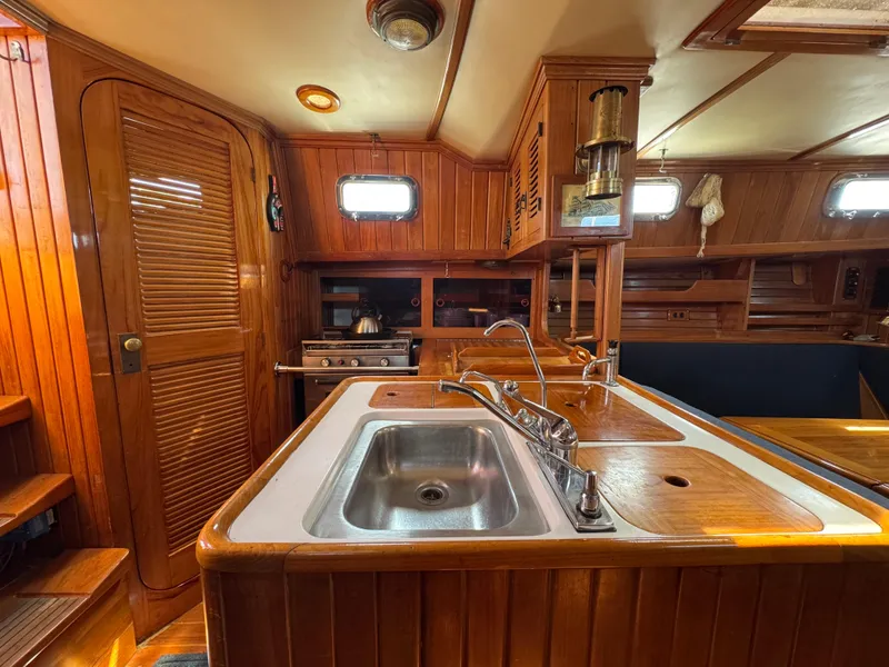 Slide: The Image of Luxurious 1988 Cabo Rico 38XL yacht interior with wooden cabinetry and modern kitchen amenities. - 40