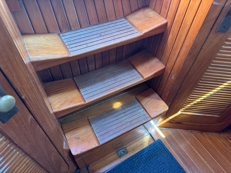 Slide: The Image of Wooden steps inside a 1988 Cabo Rico 38XL yacht, featuring a classic nautical design. - 47