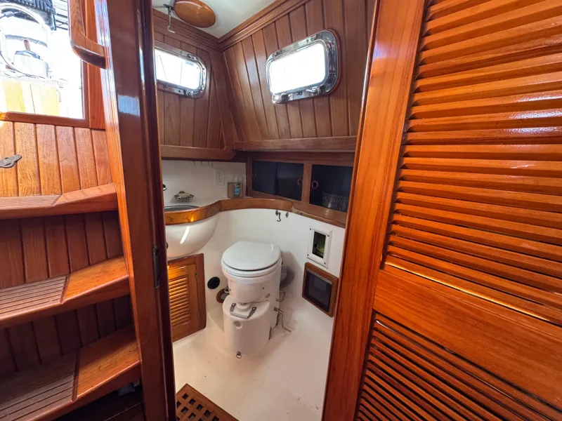 Slide: The Image of 1988 Cabo Rico 38XL yacht bathroom with wooden interior and porthole windows. - 48