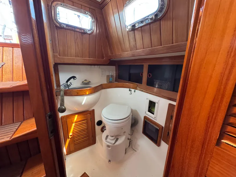 Slide: The Image of 1988 Cabo Rico 38XL yacht bathroom with wooden interior and porthole windows. - 49