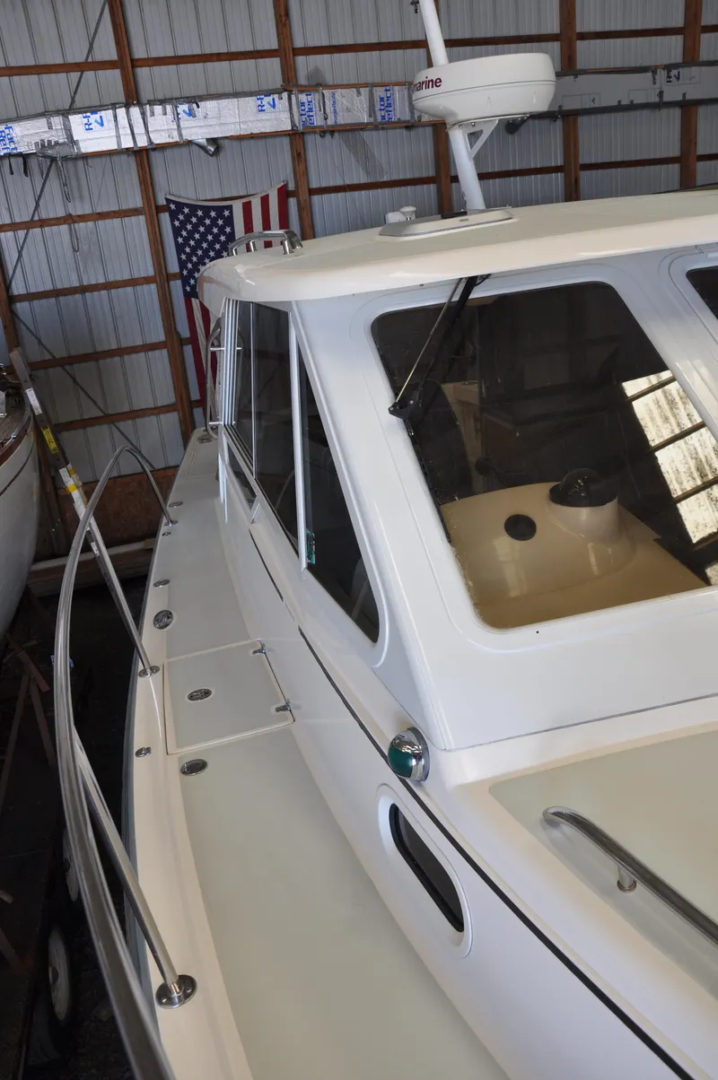 Slide: The Image of 2005 True North 33 boat in storage, featuring a sleek white exterior and spacious cabin. - 11