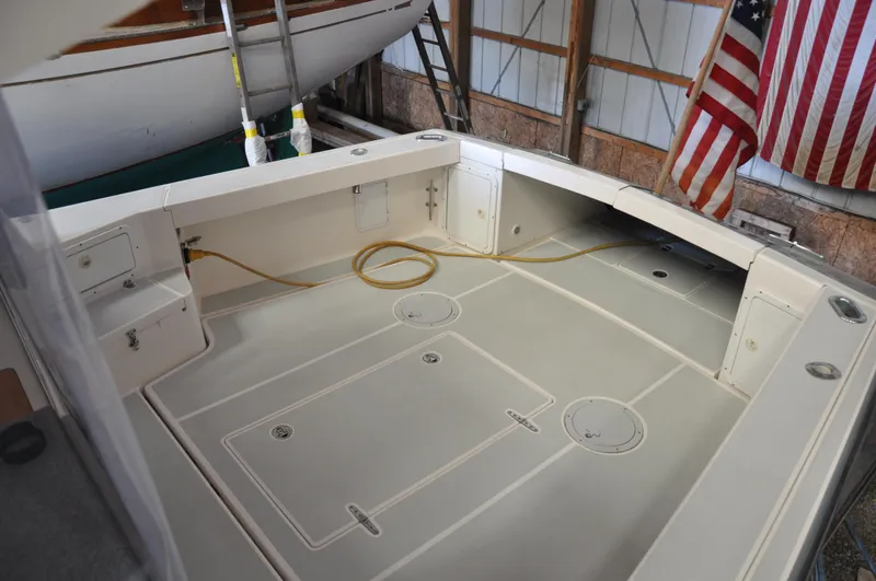 Slide: The Image of 2005 True North 33 boat deck with storage compartments and American flag in a boathouse. - 13