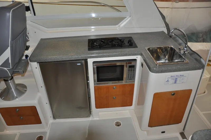 Slide: The Image of Compact boat galley with stove, sink, fridge, and microwave in a 2005 True North 33. - 17