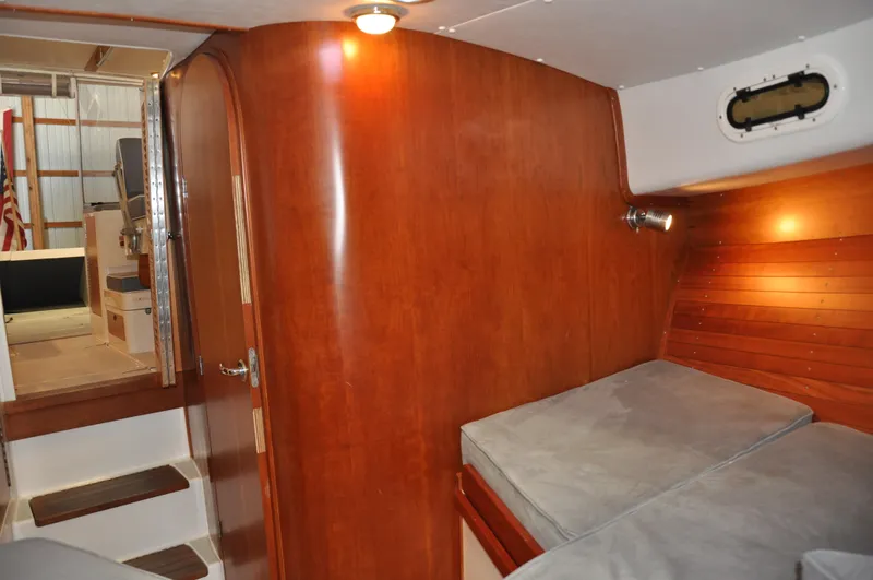 Slide: The Image of Interior of 2005 True North 33 boat with wooden paneling and cozy sleeping area. - 29