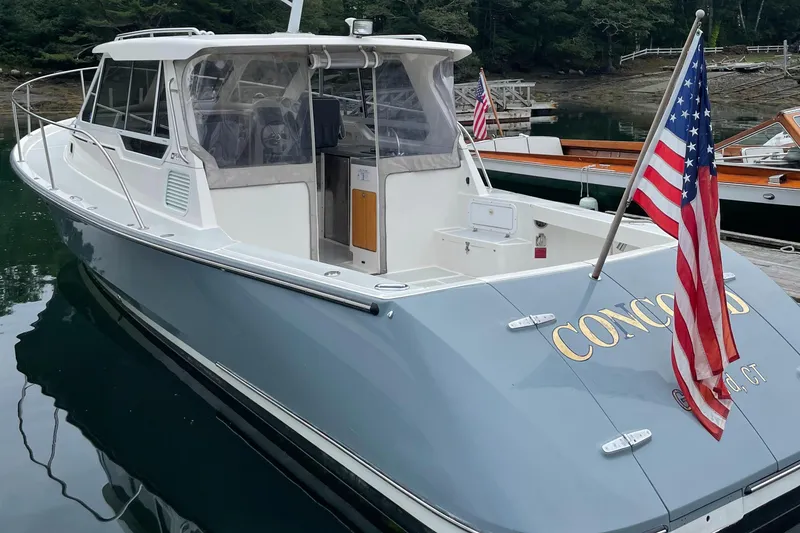 Slide: The Image of 2005 True North 33 boat docked, featuring American flag and sleek design. - 3