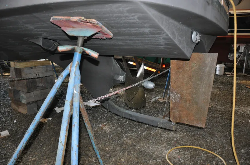 Slide: The Image of Bottom view of a 2005 True North 33 boat on stands, showing propeller and rudder. - 35