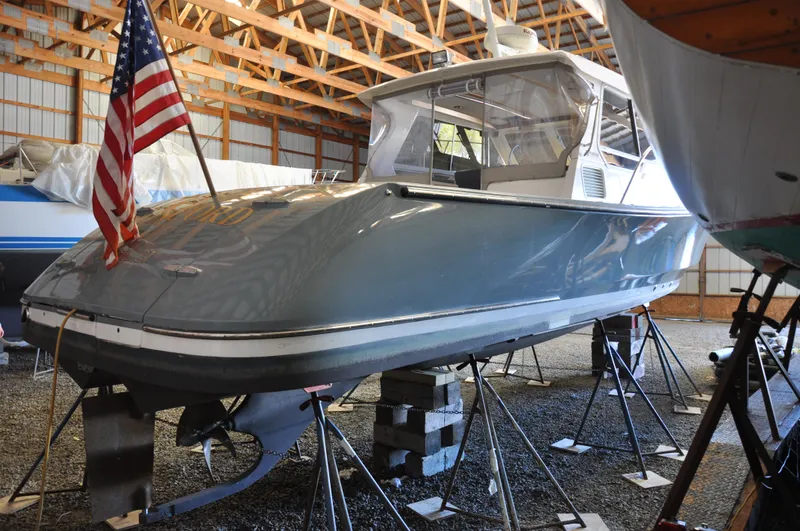 Slide: The Image of 2005 True North 33 boat in storage, elevated on blocks, with American flag. - 37