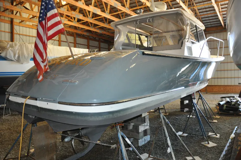 Slide: The Image of 2005 True North 33 boat in storage, supported by stands, with an American flag. - 38