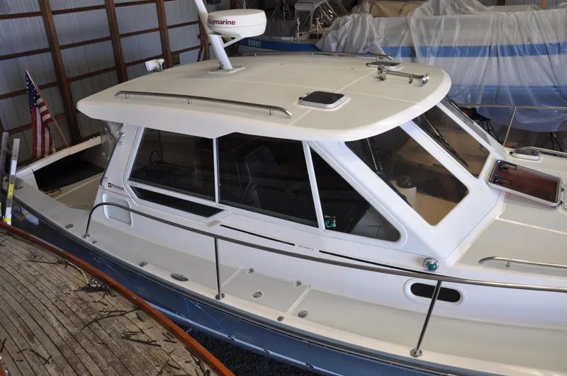 Slide: The Image of 2005 True North 33 boat in storage, featuring a sleek white cabin and American flag. - 7