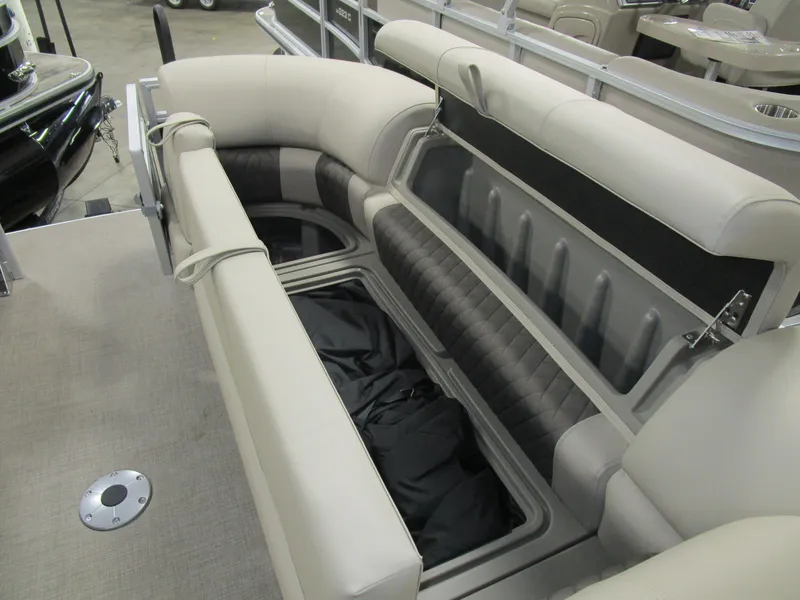 Slide: The Image of 2025 Sun Tracker Sport Fish 22 boat with open storage compartment and cushioned seating. - 2