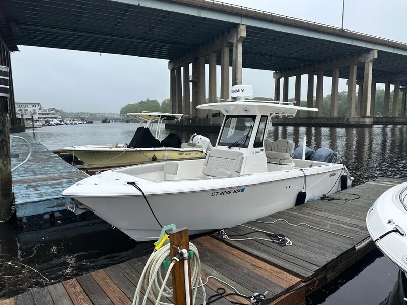 Slide: The Image of 2022 Pursuit S 268 boat docked under a bridge on a calm river. - 0