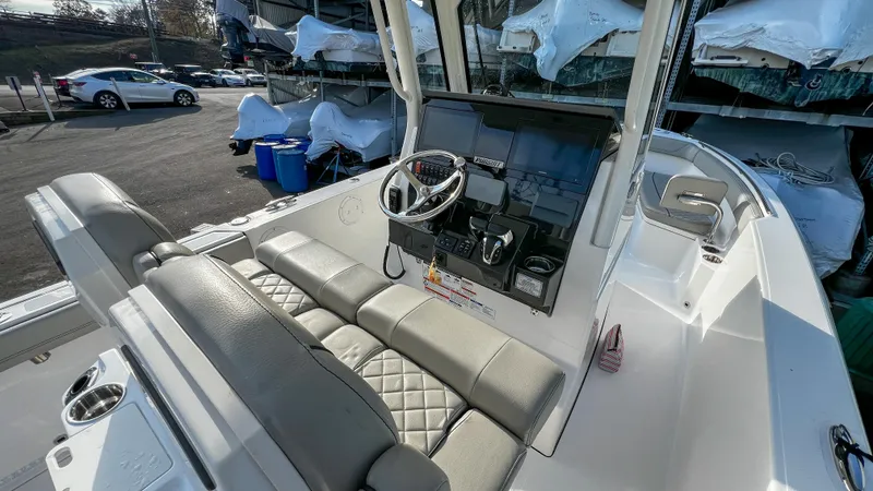 Slide: The Image of 2022 Pursuit S 268 boat interior with steering wheel and cushioned seating. - 16