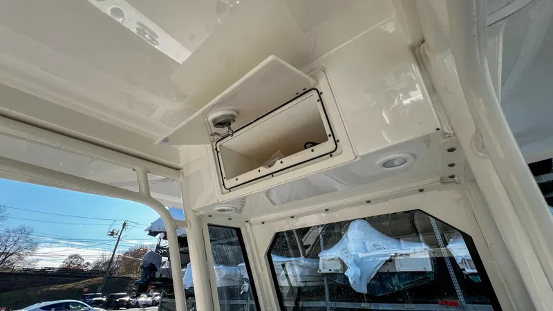Slide: The Image of 2022 Pursuit S 268 boat interior with open storage compartment and windows. - 17