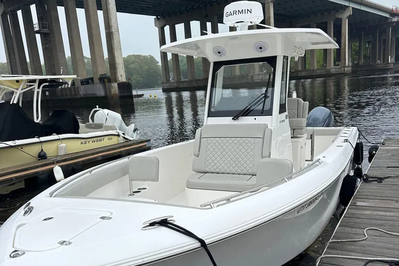 Slide: The Image of 2022 Pursuit S 268 boat docked by a bridge, featuring Garmin equipment. - 2