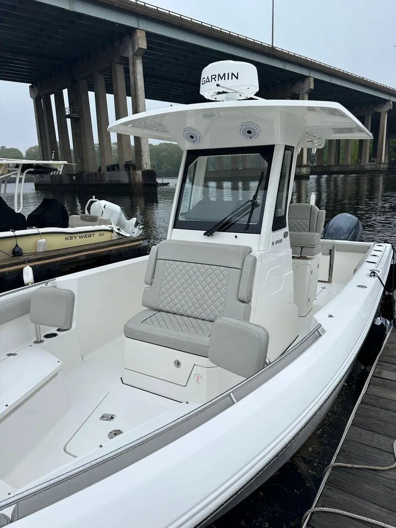 Slide: The Image of 2022 Pursuit S 268 boat docked near a bridge, featuring Garmin equipment. - 3