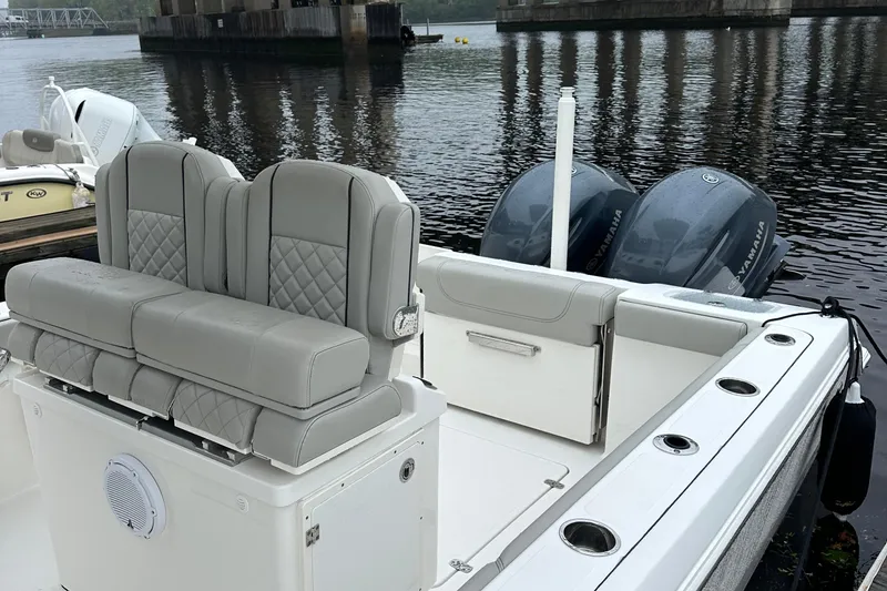 Slide: The Image of 2022 Pursuit S 268 boat with dual engines and cushioned seating on a calm river. - 4