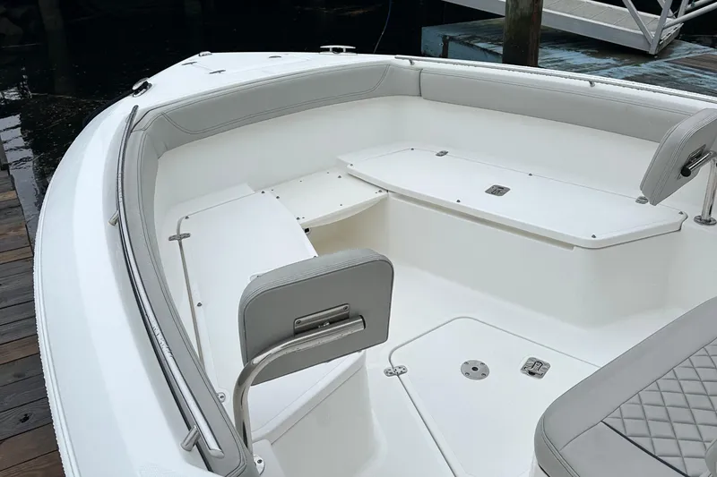 Slide: The Image of 2022 Pursuit S 268 boat interior with white seating and storage compartments. - 7