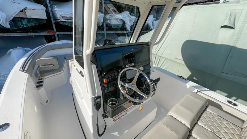 Slide: The Image of 2022 Pursuit S 268 boat cockpit with steering wheel and seating area. - 9
