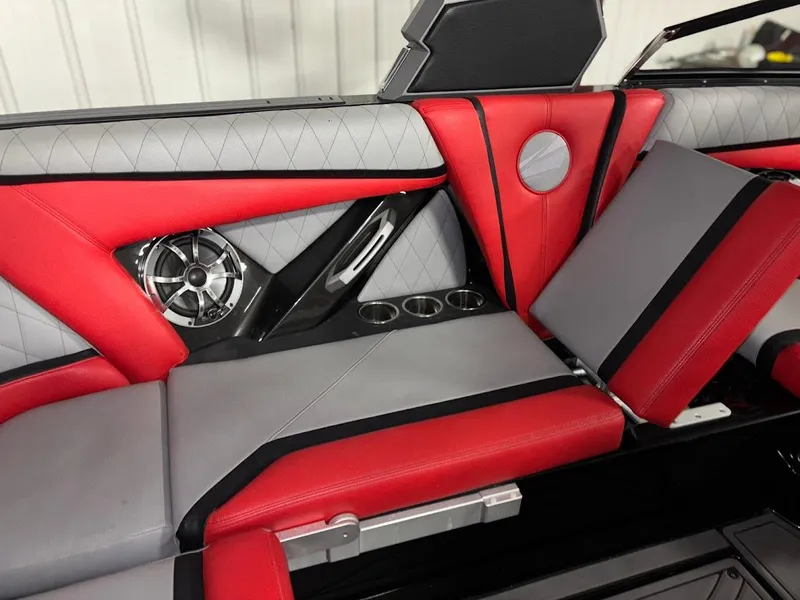 Slide: The Image of 2018 Tigé RZX3 boat interior with red and gray seating, speaker, and cup holders. - 15