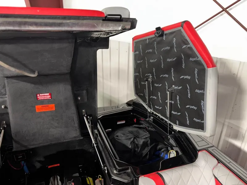 Slide: The Image of Open storage compartment of a 2018 Tigé RZX3 boat, showing interior details. - 18