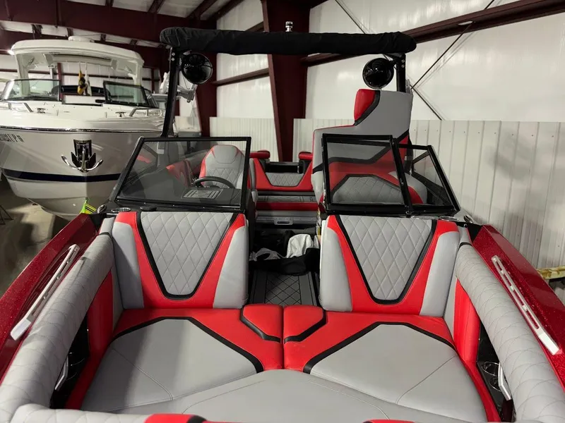 Slide: The Image of 2018 Tigé RZX3 boat interior with red and gray seating in a storage facility. - 3