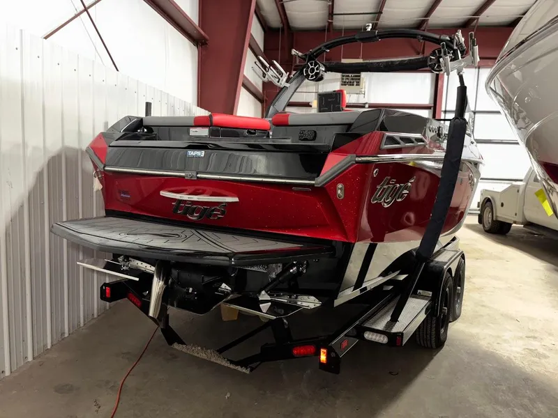 Slide: The Image of 2018 Tigé RZX3 boat in storage, red and black exterior, on a trailer. - 5