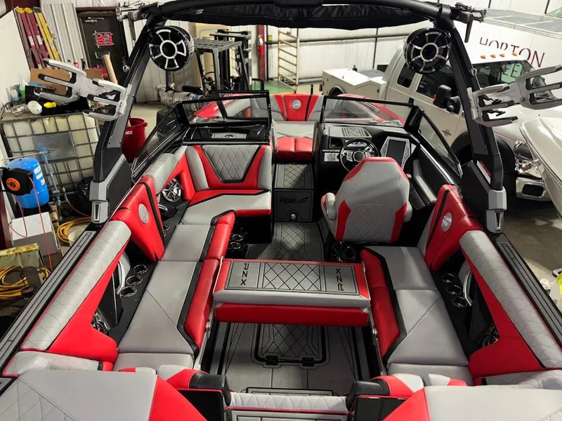 Slide: The Image of 2018 Tigé RZX3 boat interior with red and gray seating, advanced sound system, and sleek design. - 9