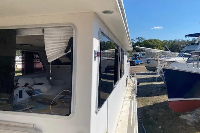 Slide: The Image of 1989 Gibson 50 Classic boat docked, featuring a white exterior and visible interior through windows. - 10
