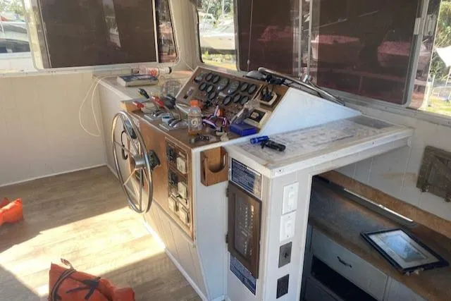 Slide: The Image of 1989 Gibson 50 Classic boat helm with steering wheel, control panel, and navigation equipment. - 5