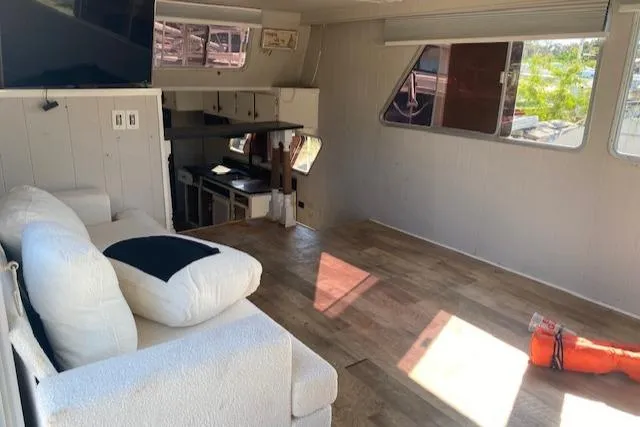 Slide: The Image of Interior of 1989 Gibson 50 Classic boat with sofa, TV, and wooden flooring. - 6
