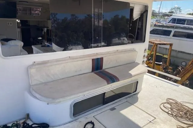 Slide: The Image of Outdoor seating area on a 1989 Gibson 50 Classic boat, featuring a cushioned bench. - 9