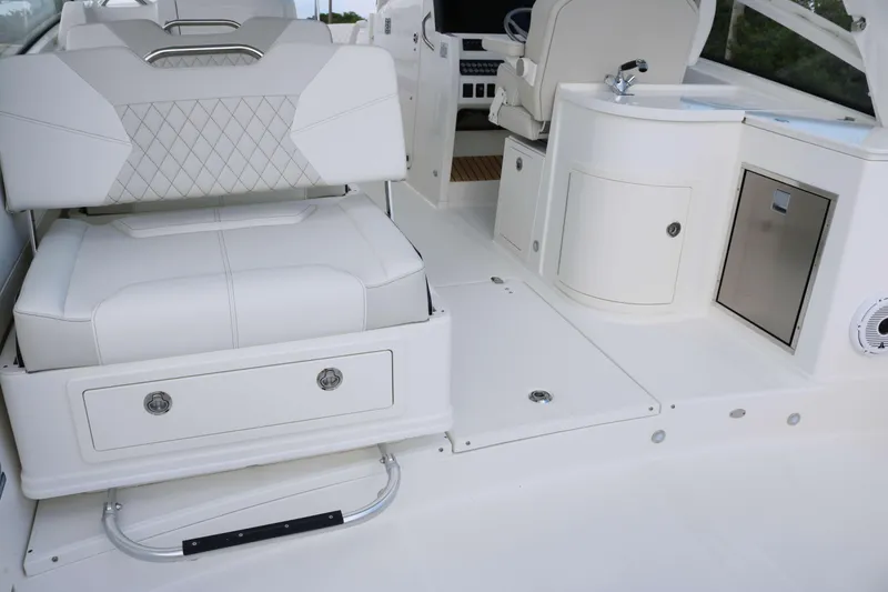 Slide: The Image of Luxurious interior of 2026 World Cat 325 DC boat with white seating and storage. - 18