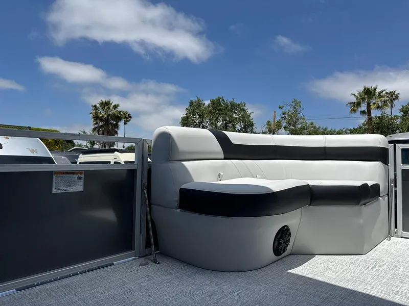 Slide: The Image of 2025 South Bay 18CR SE S Cruise pontoon boat interior with plush seating under a clear sky. - 13