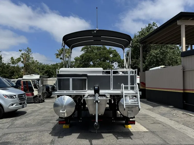 Slide: The Image of 2025 South Bay 18CR SE S Cruise pontoon boat, rear view, parked outdoors. - 22