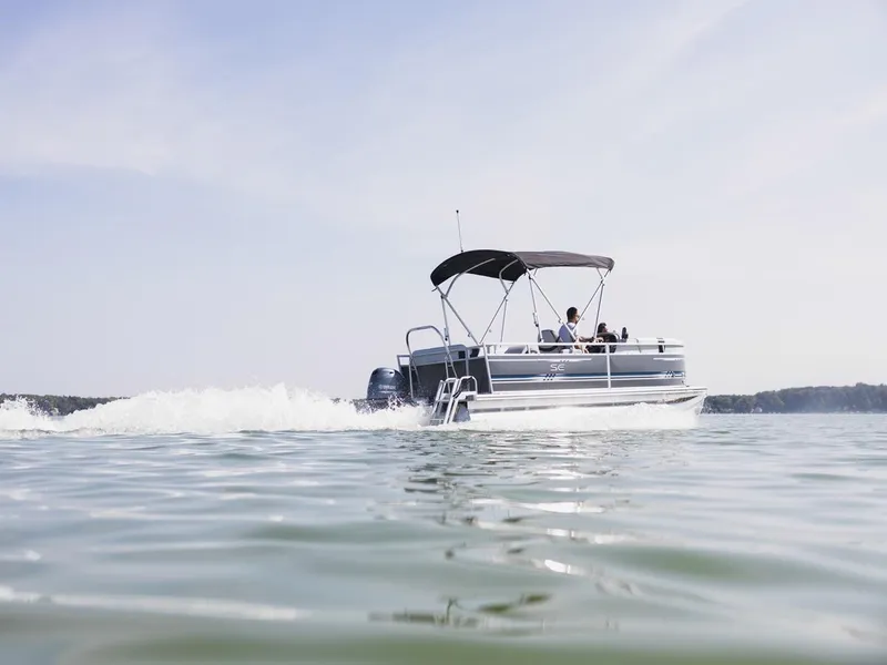 Slide: The Image of 2025 South Bay 18CR SE S Cruise pontoon boat cruising on a calm lake. - 27