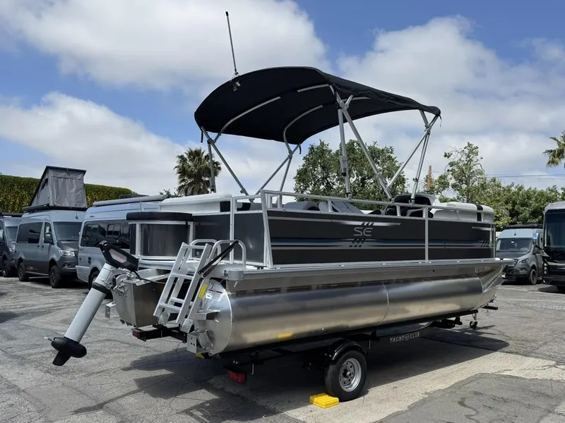 Slide: The Image of 2025 South Bay 18CR SE S Cruise pontoon boat with canopy, parked outdoors. - 3