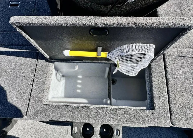 Slide: The Image of 2025 Lund 1875 Crossover XS boat storage compartment with net and yellow handle tool. - 17
