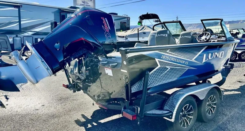 Slide: The Image of 2025 Lund 1875 Crossover XS boat with powerful outboard motor on a trailer. - 4