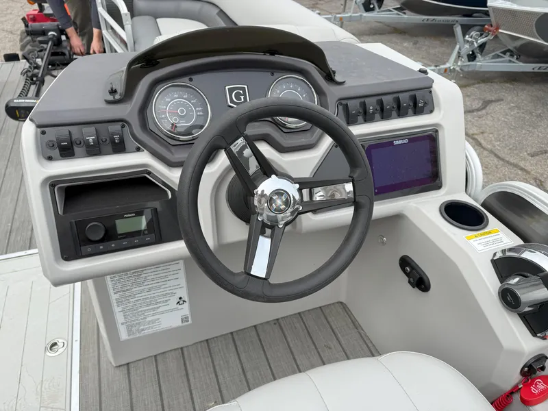 Slide: The Image of 2023 Godfrey Sweetwater 2286 FS boat dashboard with steering wheel and control panel. - 10