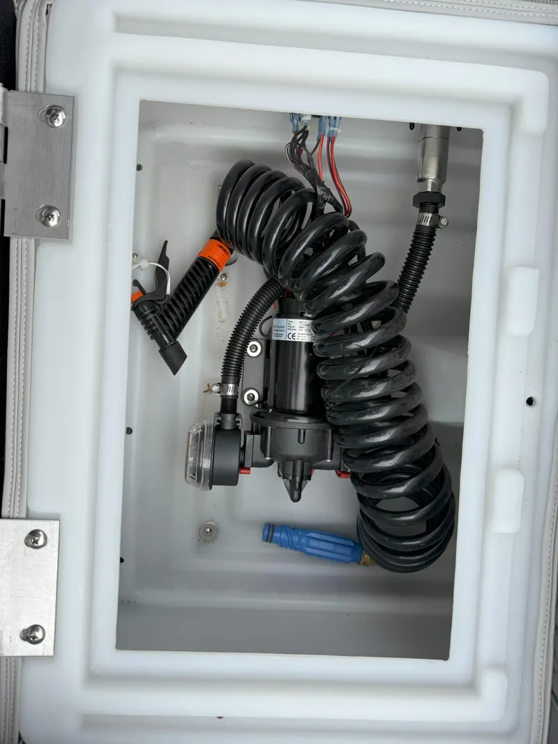 Slide: The Image of 2023 Godfrey Sweetwater 2286 FS boat compartment with coiled wiring and components. - 19