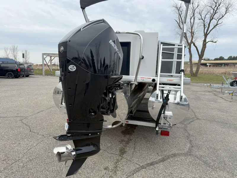 Slide: The Image of 2023 Godfrey Sweetwater 2286 FS pontoon boat with Mercury outboard motor, parked on pavement. - 6