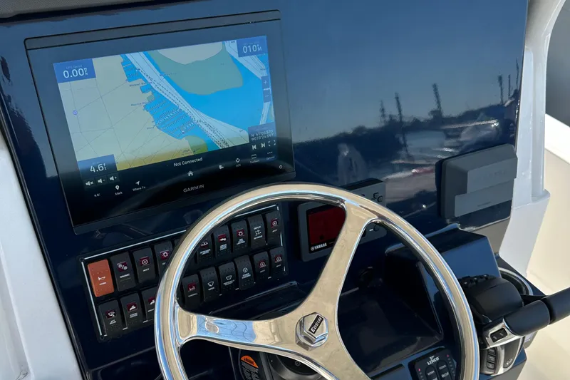 Slide: The Image of 2024 Pursuit S 268 boat dashboard with navigation screen and steering wheel. - 11