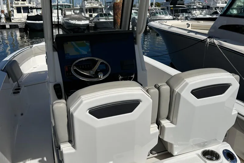 Slide: The Image of 2024 Pursuit S 268 boat interior with helm and seating at marina. - 12