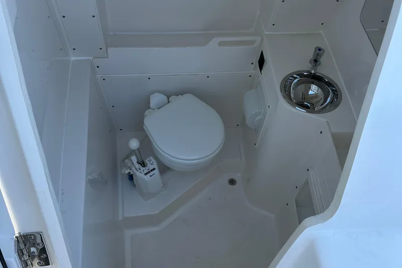 Slide: The Image of 2024 Pursuit S 268 boat interior bathroom with toilet and sink. - 13