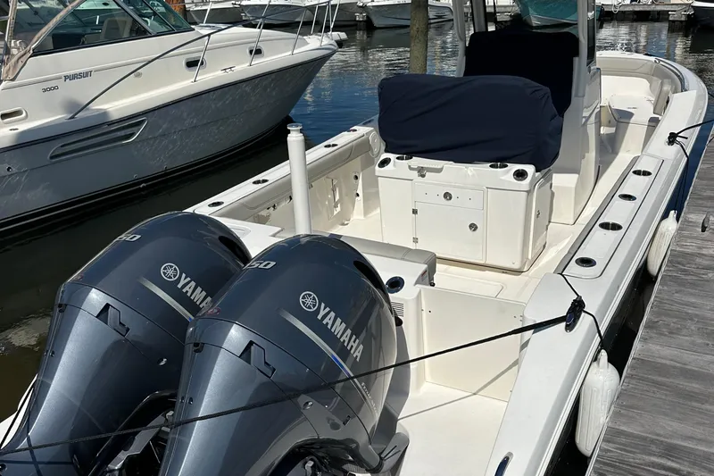 Slide: The Image of 2024 Pursuit S 268 boat with twin Yamaha engines docked at a marina. - 15