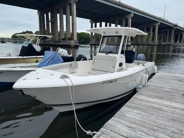 Slide: The Image of 2024 Pursuit S 268 boat docked under a bridge on a calm river. - 16