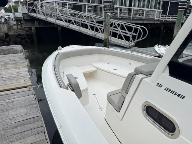 Slide: The Image of 2024 Pursuit S 268 boat docked, showcasing spacious seating and sleek design. - 17